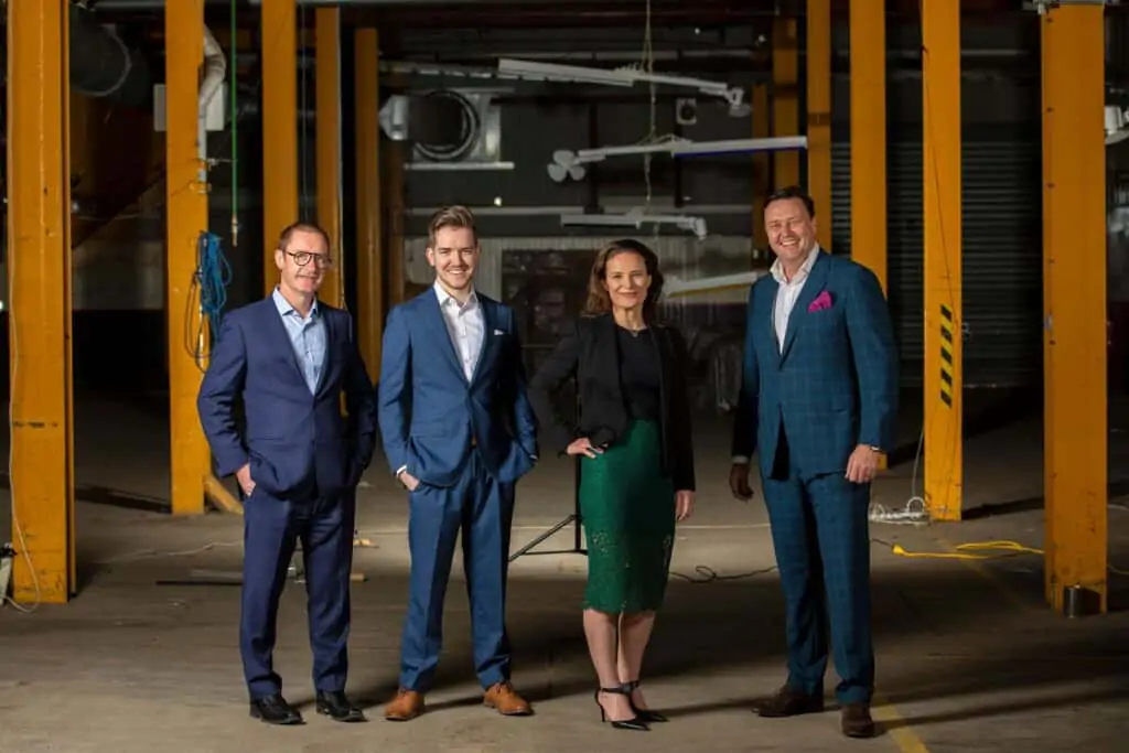 Vaxa Group posing for a photograph in a dark workshop