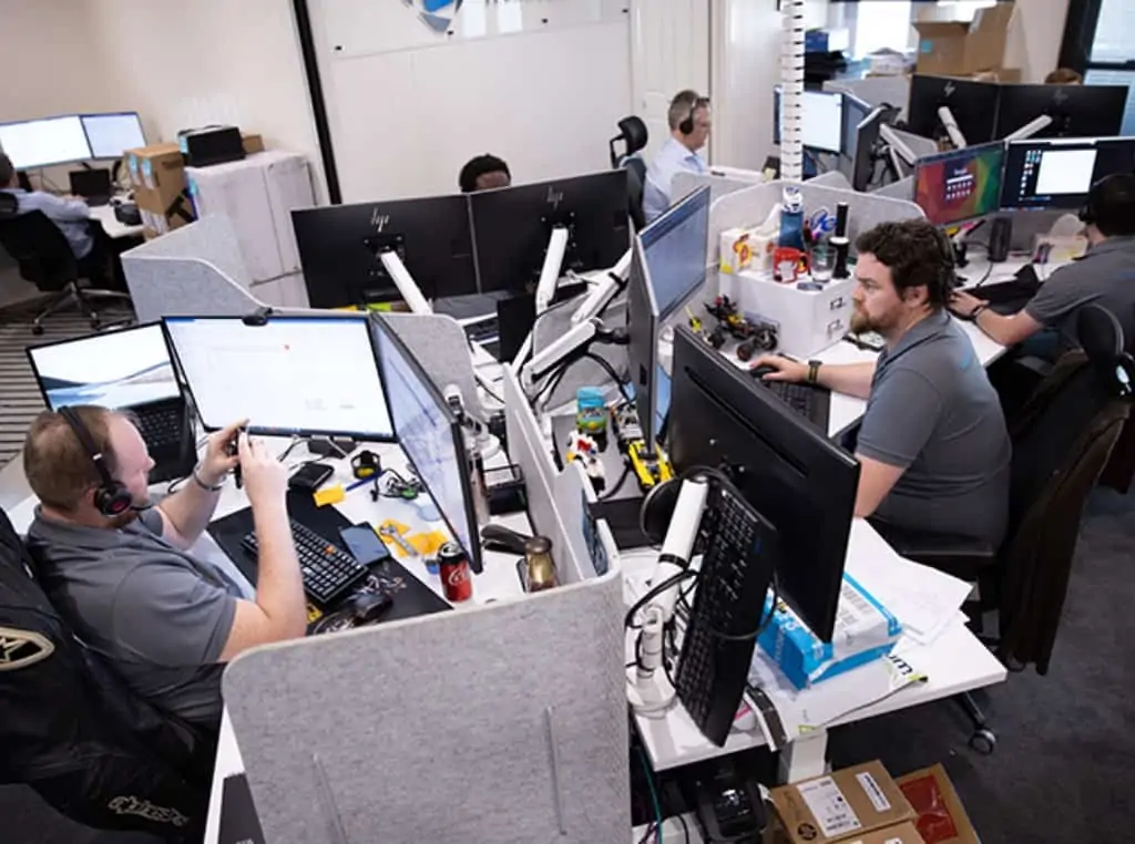 A photograph of the Envisage Technology team at their computers work, taken from a high angle