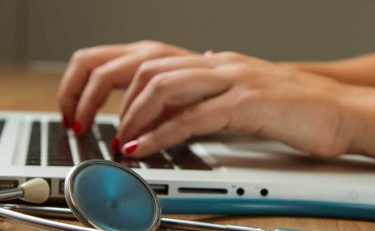 A medical professional working on a laptop