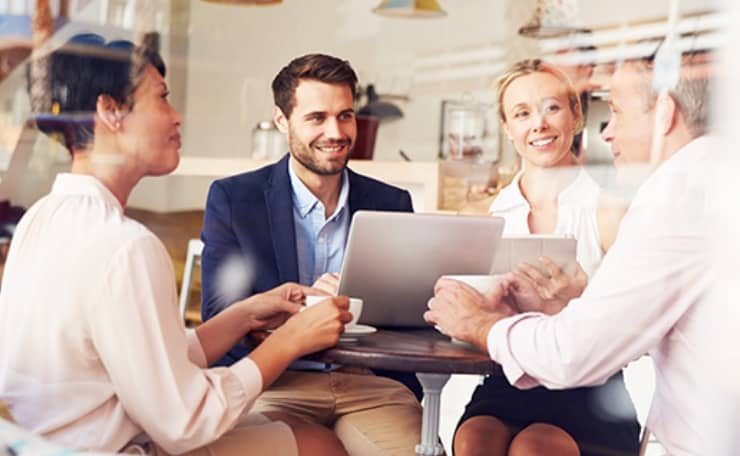 team gathered around a laptop discussing professional services