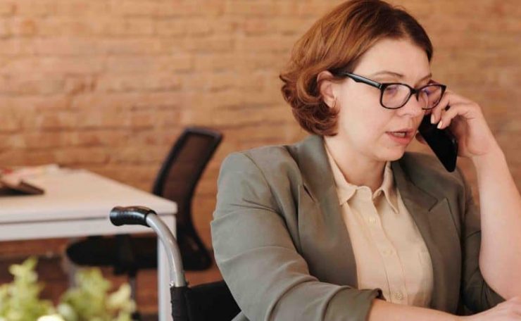 A woman wearing glassing on a phone call in an office