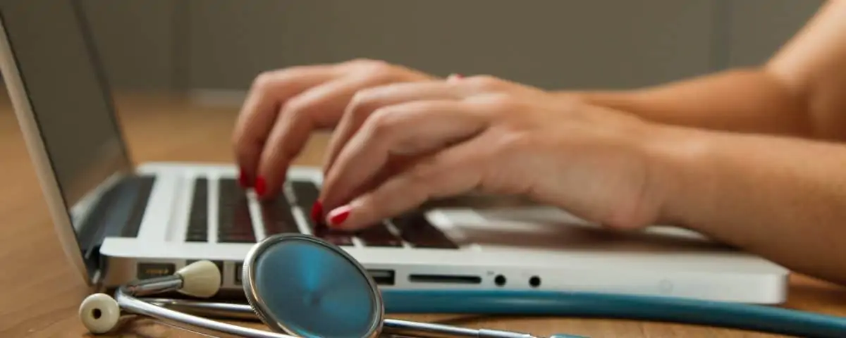 A medical professional working on a laptop