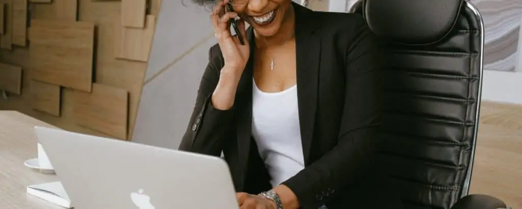 A woman in an office working on a apple laptop