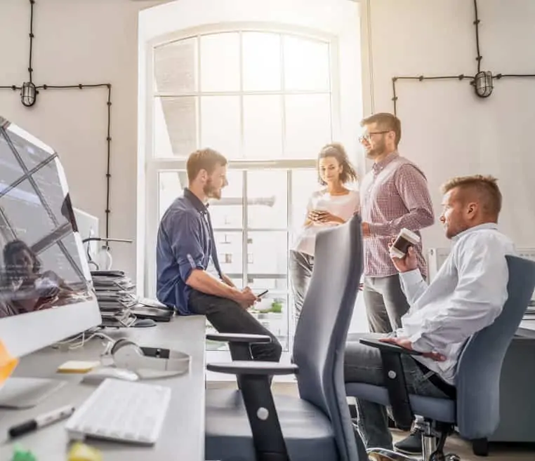 A team of professionals in an office environment discussing strategy