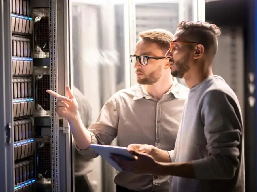 Two IT technicians checking data backup progress