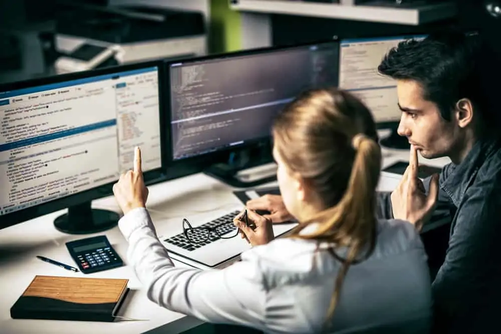 Person teaching a student how to code and develop programs