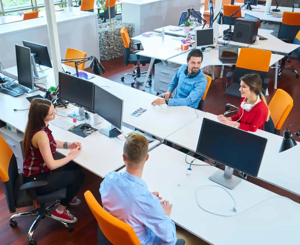People in an office environment with orange chairs