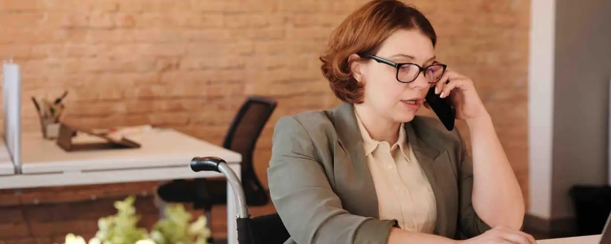 A woman wearing glassing on a phone call in an office